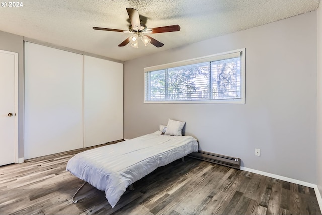 bedroom featuring ceiling fan, a textured ceiling, hardwood / wood-style flooring, and a closet