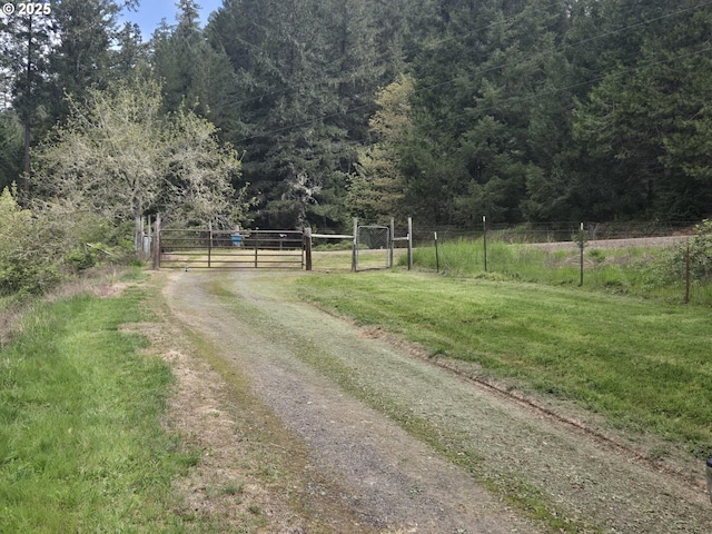 view of street featuring a forest view and a gate