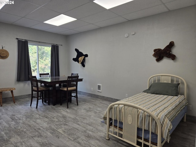bedroom with baseboards and a drop ceiling