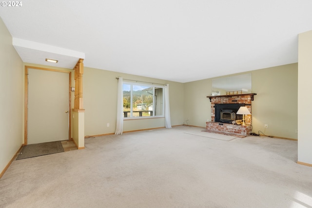 unfurnished living room with carpet floors and a wood stove