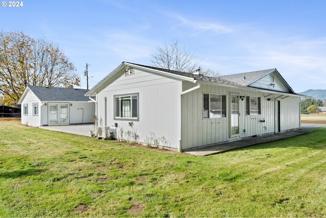 rear view of house with a patio and a yard