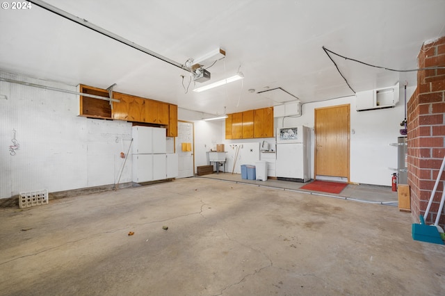 garage with white fridge, a garage door opener, and sink