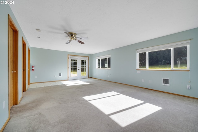 unfurnished room with french doors, ceiling fan, a healthy amount of sunlight, and light colored carpet