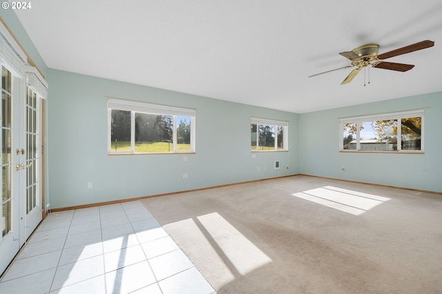 spare room with french doors, ceiling fan, plenty of natural light, and light tile patterned floors