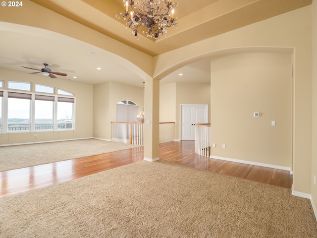 spare room featuring ceiling fan with notable chandelier and light hardwood / wood-style floors