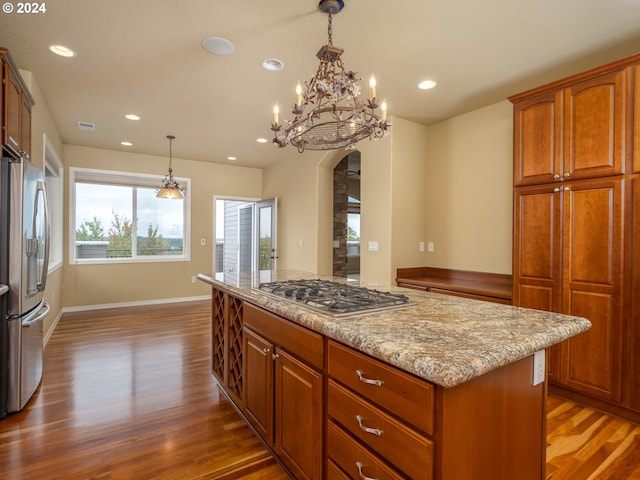 kitchen with stainless steel appliances, hanging light fixtures, and dark hardwood / wood-style flooring