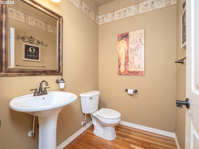 bathroom with wood-type flooring, sink, and toilet