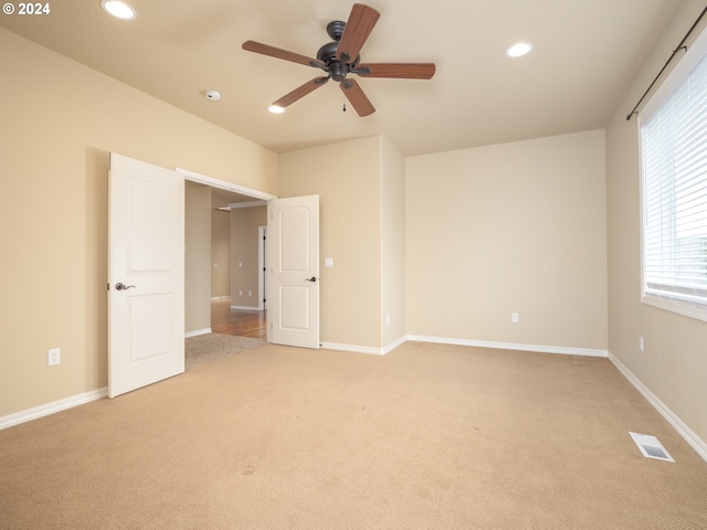 unfurnished bedroom with ceiling fan and light colored carpet