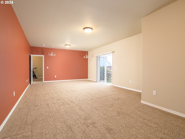 unfurnished room with a notable chandelier and carpet