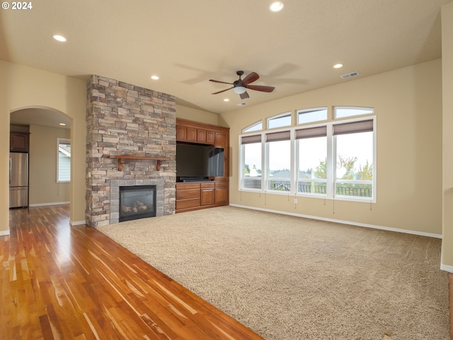 unfurnished living room with a fireplace, wood-type flooring, and ceiling fan