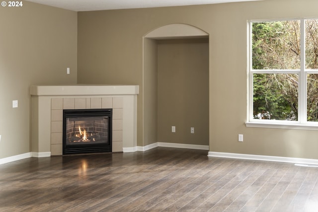 unfurnished living room with a fireplace and dark wood-type flooring