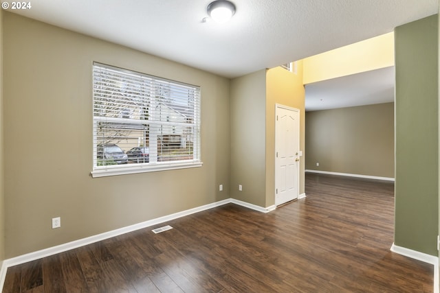 empty room with dark hardwood / wood-style flooring