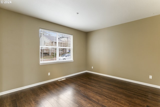 unfurnished room with dark hardwood / wood-style flooring