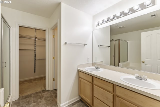 bathroom with vanity and a shower with door