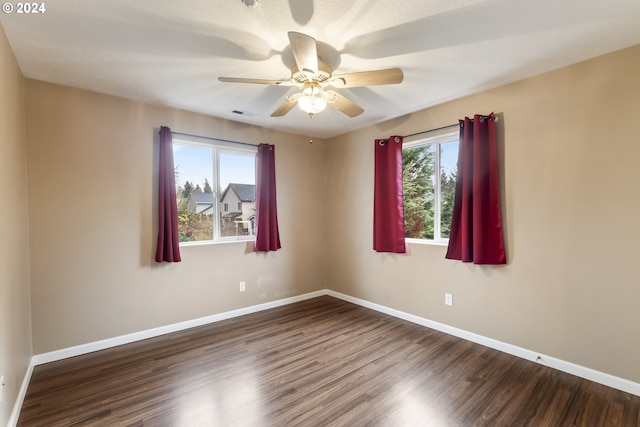 spare room with ceiling fan and dark hardwood / wood-style floors