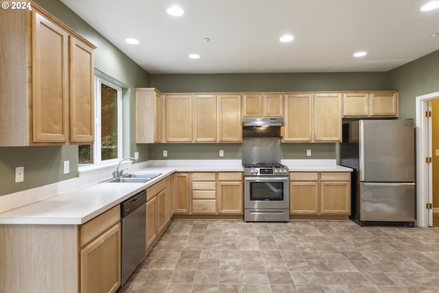 kitchen with light brown cabinetry, stainless steel appliances, and sink