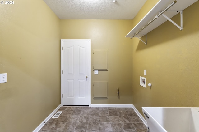 clothes washing area with a textured ceiling and hookup for a washing machine