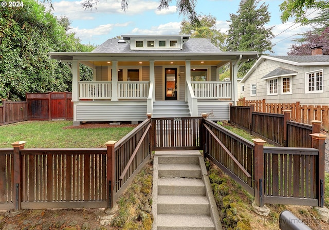 back of property featuring a yard and covered porch