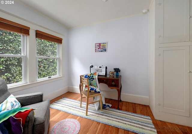 office area with crown molding and light wood-type flooring