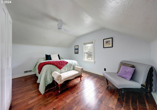 bedroom featuring ceiling fan, a textured ceiling, dark hardwood / wood-style floors, and vaulted ceiling