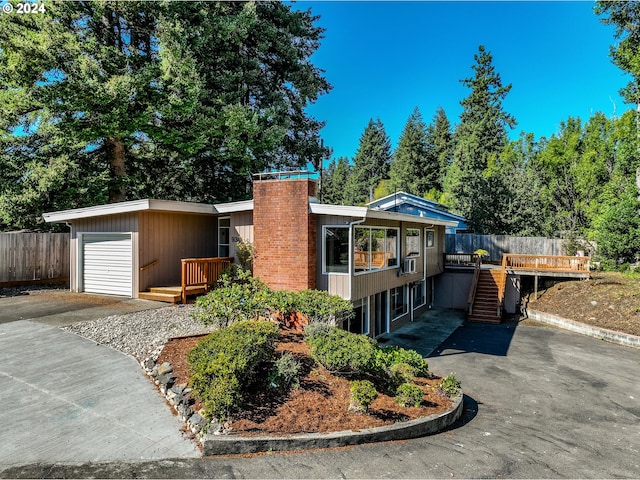 view of front of property with fence, a chimney, a deck, and stairway