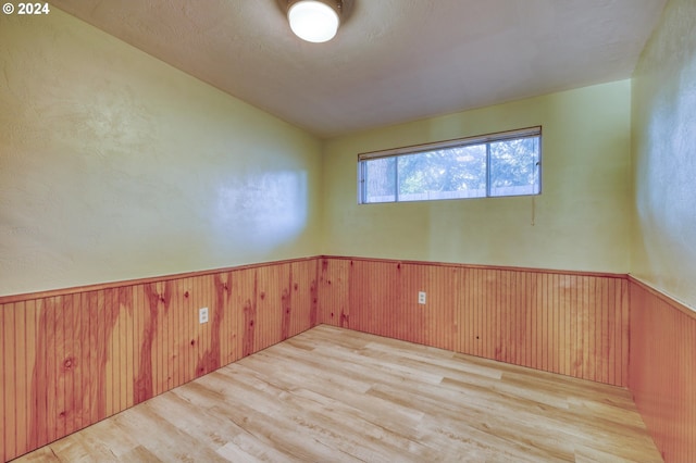 spare room with wooden walls and light hardwood / wood-style floors