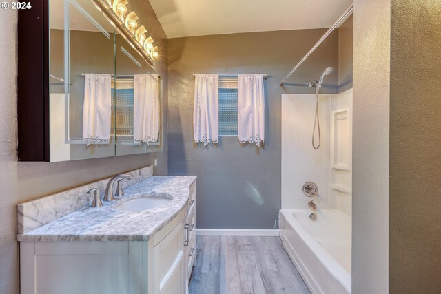 full bathroom featuring baseboards, bathing tub / shower combination, vanity, and wood finished floors