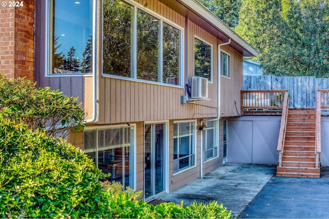 exterior space with stairs, cooling unit, and fence