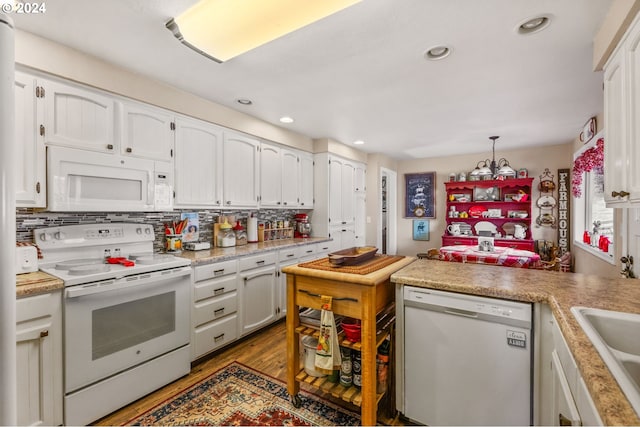 kitchen with hanging light fixtures, light hardwood / wood-style floors, white cabinetry, decorative backsplash, and white appliances