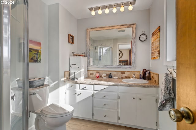 bathroom featuring walk in shower, hardwood / wood-style floors, vanity, and toilet