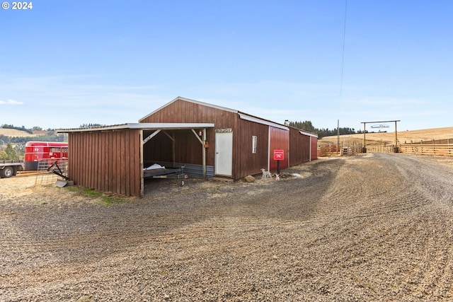 view of horse barn featuring a rural view