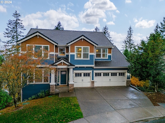 craftsman-style home featuring a garage and a front yard