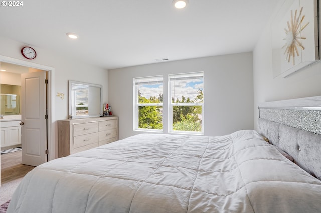 bedroom with ensuite bathroom and wood-type flooring