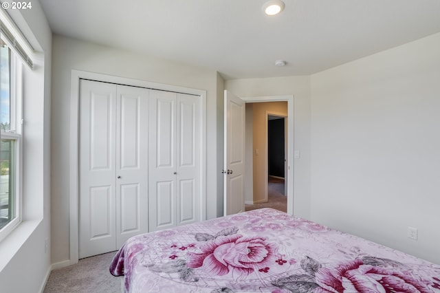 carpeted bedroom featuring multiple windows and a closet