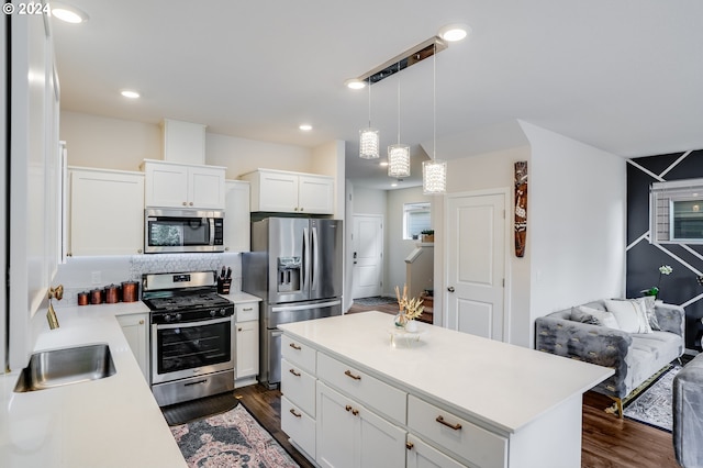 kitchen with tasteful backsplash, stainless steel appliances, hanging light fixtures, dark hardwood / wood-style flooring, and white cabinets