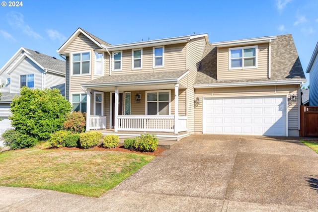 view of front of house with a front yard, a garage, and a porch