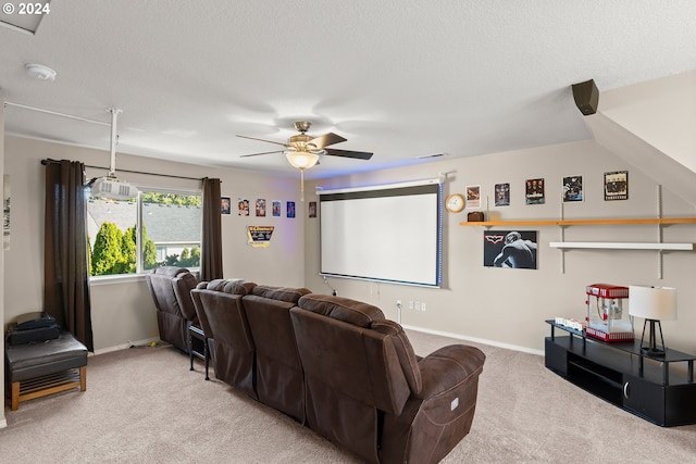 home theater room with ceiling fan, carpet flooring, and a textured ceiling