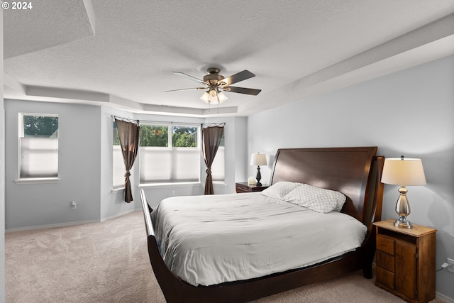 carpeted bedroom featuring ceiling fan and a textured ceiling