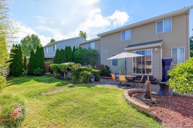 rear view of house with a lawn and a patio area