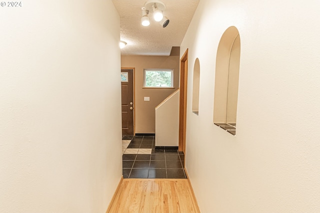 hall featuring a textured ceiling and dark hardwood / wood-style floors