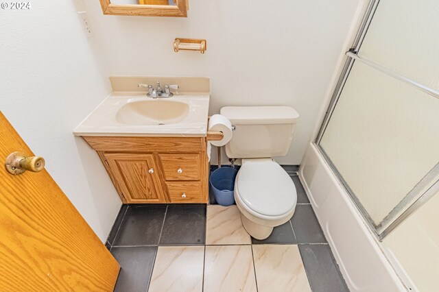 full bathroom featuring tile patterned flooring, shower / bath combination with glass door, vanity, and toilet