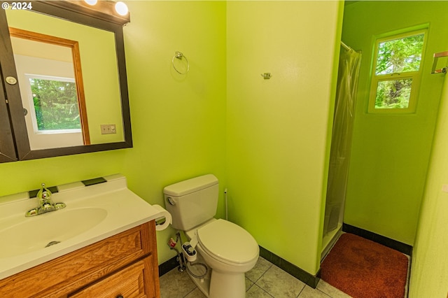 bathroom with a healthy amount of sunlight, curtained shower, vanity, and toilet