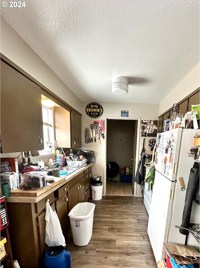 kitchen featuring ceiling fan, a textured ceiling, white fridge, and hardwood / wood-style flooring