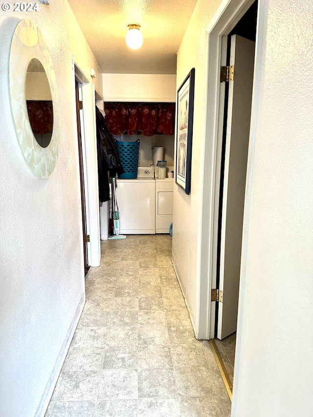 hallway with washing machine and dryer and light tile flooring