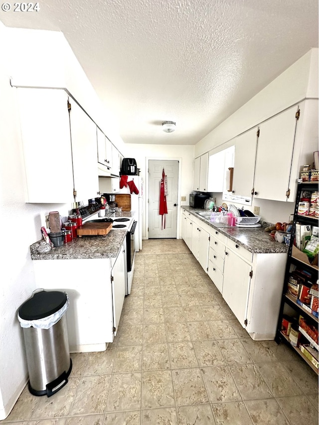 kitchen featuring white cabinetry, sink, light tile flooring, and white electric range