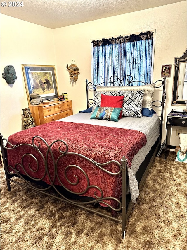 bedroom with a textured ceiling and dark carpet