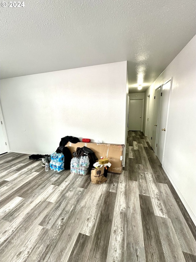 hall featuring a textured ceiling and dark wood-type flooring