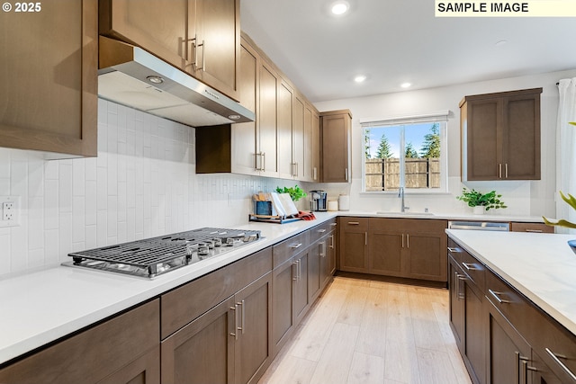 16910 NE 38th Ave, Vancouver, WA 98686 - kitchen with stainless steel gas cooktop, a sink, decorative backsplash, light countertops, and under cabinet range hood