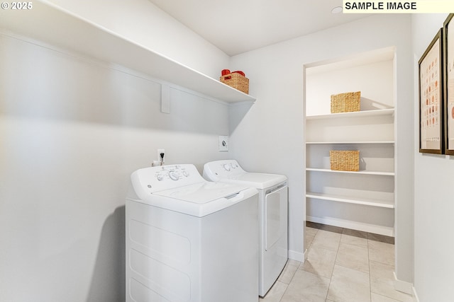 laundry room featuring washing machine and clothes dryer and light tile patterned floors