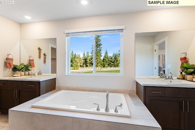 bathroom with vanity and tiled bath